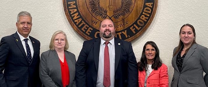 School Board members pose for picture in front of the District seal.