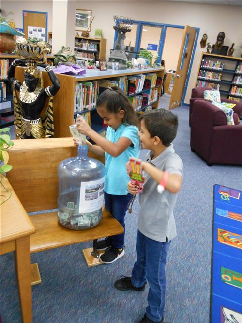 Panther CUBS drop pennies in the jar