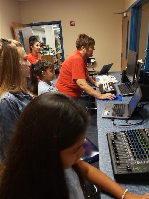 teacher and students working on computer