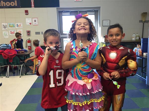 three smiling students in costume pose for a picture