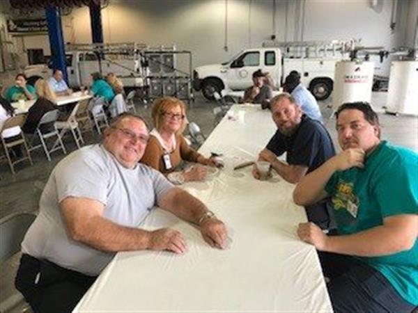 staff sitting at table lean in for a photo