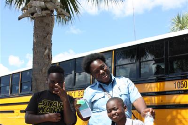 bus driver and students pose for a photo